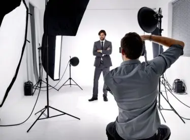 A photographer taking an actor with a beard's headshots.