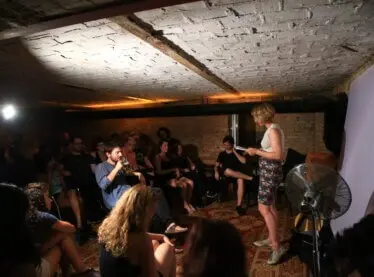 A poet reading her work at a poetry slam event.