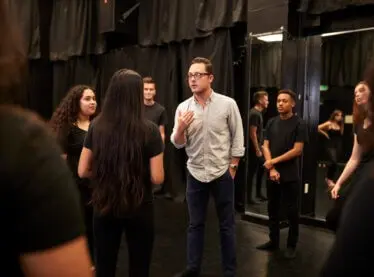 An acting teacher coaches a class on how to act natural.