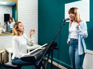 A vocal coach training one of her students.
