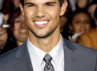 Twilight Actor Taylor Lautner in a suit and tie at an event smiling.