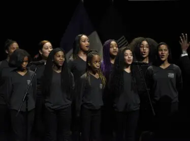 A group of diverse choir members singing.