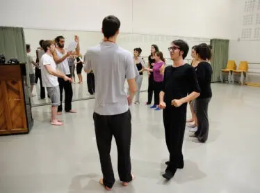 An acting class being guided by their instructor.