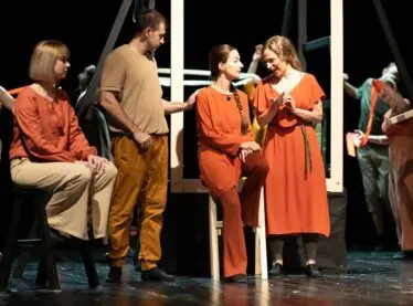 An ensemble of actors putting on a performance in a local theatre.