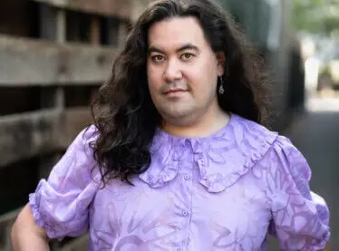 Casting Director Rhys Velasquez outside in a purple shirt.
