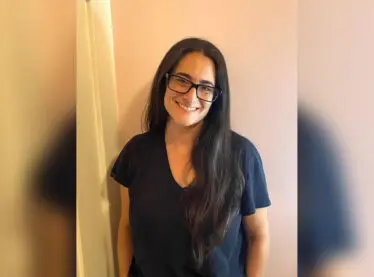 Jennifer Ricchiazzi standing in a hallway smiling.