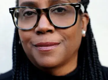 Kim Coleman, a casting director, smiling in a black sweater.