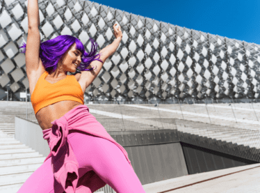 actor with purple hair dances outside and living her best life