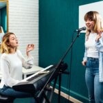 A vocal coach training one of her students.