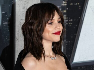 Jenna Ortega attending an event in front of a black and white backdrop.