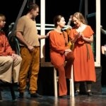 An ensemble of actors putting on a performance in a local theatre.
