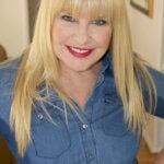 Acting coach Amy Lyndon posing and smiling at home.