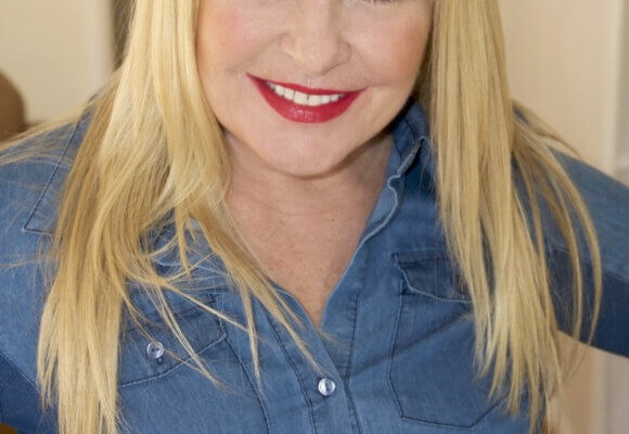 Acting coach Amy Lyndon posing and smiling at home.