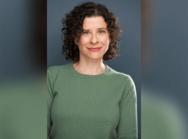 Casting director Kate Geller smiling in a green sweater.