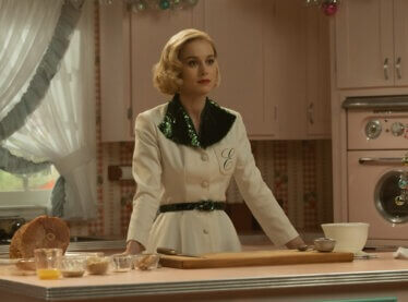 Brie Larson in a white 1950s shirt in the kitchen cooking.