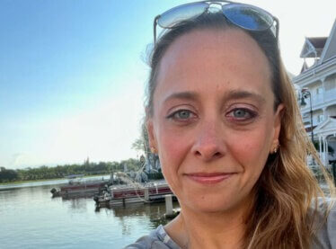Selfie of casting director Maribeth Fox smiling outside by the water.
